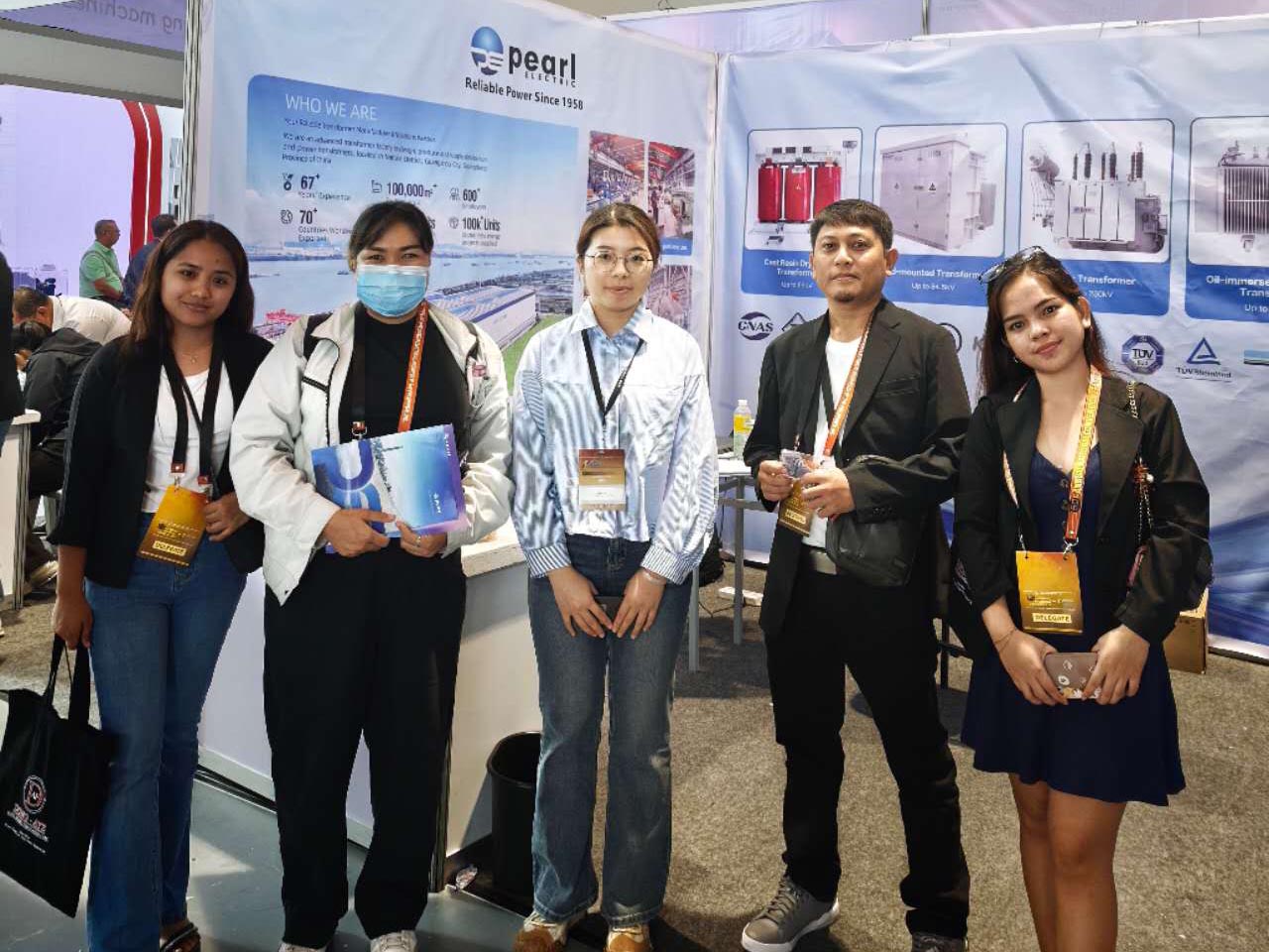 El ingeniero de ventas de transformadores de Pearl Electric posa para una fotograf&iacute;a con un cliente de Filipinas